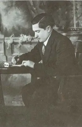 A black-and-white photo of a man in a suit sitting at a wooden table, writing with a pen on paper. The background features a decorative wall with foliage. The setting appears formal, possibly from the early 20th century. Dominion Roofing | BRAMPTON | BURLINGTON | ETOBICOKE | MARKHAM | MISSISSAUGA | NORTH YORK | OAKVILLE | RICHMOND HILL | Scarborough | TORONTO | VAUGHAN | dominionroofing.com | Phone Number: 416-789-0601
