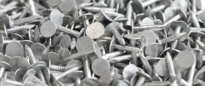 A close-up view of a large pile of silver-colored metal nails scattered randomly. The nails have flat, round heads and sharp pointed ends, creating a textured pattern of overlapping metal surfaces. Dominion Roofing | BRAMPTON | BURLINGTON | ETOBICOKE | MARKHAM | MISSISSAUGA | NORTH YORK | OAKVILLE | RICHMOND HILL | Scarborough | TORONTO | VAUGHAN | dominionroofing.com | Phone Number: 416-789-0601