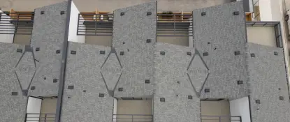 Aerial view of a row of modern buildings with geometric, overlapping rooftop designs, featuring gray shingles and small skylights. The rooftops form a zigzag pattern, creating a visually striking architectural effect. Dominion Roofing | BRAMPTON | BURLINGTON | ETOBICOKE | MARKHAM | MISSISSAUGA | NORTH YORK | OAKVILLE | RICHMOND HILL | Scarborough | TORONTO | VAUGHAN | dominionroofing.com | Phone Number: 416-789-0601